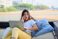 Asian businesswoman working online at the beach. Freelancer using technology for work everywhere. Woman talking with customer Royalty Free Stock Photo