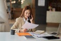 Asian businesswoman working with tiger skins notebooks graphs documents at modern desks using computers successful female e-commer