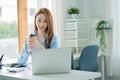 Asian businesswoman working with tiger skins notebooks graphs documents at modern desks using computers successful female e-commer