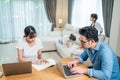 Asian busy Parents working from home due Covid-19 lockdown with children playing around. Business Father and Mother typing laptop Royalty Free Stock Photo