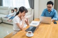 Asian busy Parents working from home due Covid-19 lockdown with children playing around. Business Father and Mother typing laptop Royalty Free Stock Photo