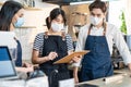 Asian Cafe manager leader explain job working to barista and waitress. Beautiful Coffeehouse worker wear mask due to Covid19 Royalty Free Stock Photo