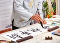 Asian caligraphy. The master of Chinese Caligraphy writes on rice paper characters and hieroglyphs that read Xin nian Royalty Free Stock Photo