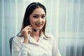 Enthusiastic asian call center with headset on her workplace portrait. Royalty Free Stock Photo