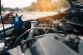 Asian car mechanic holds a wrench and a bottle of lure oil, ready to repair the car Royalty Free Stock Photo