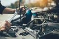 Asian car mechanic holds a wrench and a bottle of lure oil, ready to repair the car Royalty Free Stock Photo