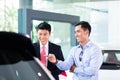 Asian Car Salesman selling auto to customer Royalty Free Stock Photo