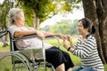 Asian care assistant or daughter is massaging palm and fingers of senior mother feel numb,elderly woman having injured hands Royalty Free Stock Photo