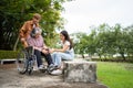 Asian careful caregiver or nurse taking care of the patient is hurting knee in wheelchair. Concept of happy retirement with care Royalty Free Stock Photo