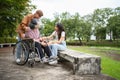 Asian careful caregiver or nurse taking care of the patient is hurting knee in wheelchair. Concept of happy retirement with care Royalty Free Stock Photo