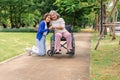 Asian careful caregiver or nurse taking care of the patient in a wheelchair. Concept of happy retirement with care from a Royalty Free Stock Photo