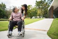 Asian careful caregiver or nurse taking care of the patient in a wheelchair. Concept of happy retirement with care from a Royalty Free Stock Photo