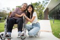 Asian careful caregiver or nurse taking care of the patient in a wheelchair. Concept of happy retirement with care from a Royalty Free Stock Photo