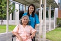 Asian careful caregiver or nurse taking care of the patient in a wheelchair. Concept of happy retirement with care from a Royalty Free Stock Photo