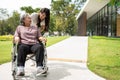 Asian careful caregiver or nurse taking care of the patient in a wheelchair. Concept of happy retirement with care from a Royalty Free Stock Photo