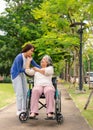 Asian careful caregiver or nurse taking care of the patient in a wheelchair. Concept of happy retirement with care from a Royalty Free Stock Photo