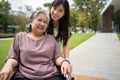 Asian careful caregiver or nurse taking care of the patient in a wheelchair. Concept of happy retirement with care from a Royalty Free Stock Photo