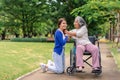 Asian careful caregiver or nurse taking care of the patient in a wheelchair. Concept of happy retirement with care from a Royalty Free Stock Photo