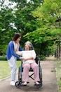 Asian careful caregiver or nurse taking care of the patient in a wheelchair. Concept of happy retirement with care from a Royalty Free Stock Photo