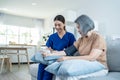 Asian caregiver doctor examine older patient use blood pressure gauge. Young woman therapist nurse at nursing home taking care of Royalty Free Stock Photo