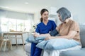 Asian caregiver doctor examine older patient use blood pressure gauge. Young woman therapist nurse at nursing home taking care of Royalty Free Stock Photo