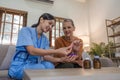 Asian caregiver nurse give consult to Caucasian senior woman 60s patient. Attractive care pharmacist hold medicine pills Royalty Free Stock Photo