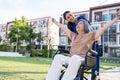 Asian caregiver nurse support old disabled woman on wheelchair outdoor. Beautiful girl doctor help and take care of senior elder Royalty Free Stock Photo