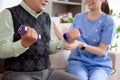 Asian caregiver woman or nurse training senior man lifting dumbbell for arm exercise while therapy and rehabilitation. Royalty Free Stock Photo