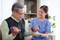 Asian caregiver woman or nurse training senior man lifting dumbbell for arm exercise while therapy. Royalty Free Stock Photo