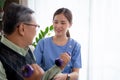 Asian caregiver woman or nurse training senior man lifting dumbbell for arm exercise while therapy and rehabilitation. Royalty Free Stock Photo