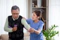 Asian caregiver woman or nurse training senior man stretch arm for exercise while therapy and rehabilitation. Royalty Free Stock Photo