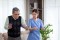 Asian caregiver woman or nurse training senior man stretch arm for exercise while therapy and rehabilitation. Royalty Free Stock Photo