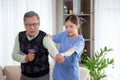 Asian caregiver woman or nurse training senior man stretch arm for exercise while therapy and rehabilitation. Royalty Free Stock Photo