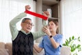 Asian caregiver woman or nurse training senior man stretch arm for exercise while therapy and rehabilitation. Royalty Free Stock Photo