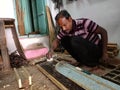 an asian carpenter measuring wood logs at workshop in india January 2020