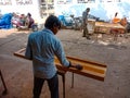 Asian carpenter polishing wooden logs in India January 2020