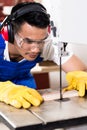 Asian carpenter or worker on saw with wood Royalty Free Stock Photo