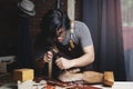 Asian Carpenter Working in Woodworking Workshop. Carving Wooden