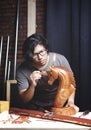 Asian Carpenter Working in Woodworking Workshop. Polishing Wooden Horse Sculpture