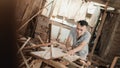 Asian carpenters cut wood planks using a circular saw