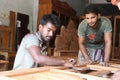 Asian carpentry workers polishing a showcase part at a furniture workshop