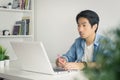 Asian Casual Businessman or Freelancer Work from Home by Laptop and Note Detail in Home Office in Vintage Tone