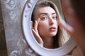 Asian caucasian woman girl unhappy touching her face an look at the mirror close up Royalty Free Stock Photo