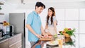 Asian cheerful loving couple talking, preparing and cooking with joy while standing on a kitchen counter at home. Cooking together Royalty Free Stock Photo