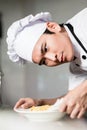 Asian chef plating up a bowl of food Royalty Free Stock Photo