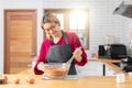 Asian chef woman blend dough and chocolate with beater for cooking chocolate cake with happy feeling in the morning