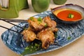 Asian chicken leg kebab on a bamboo stick with sauce