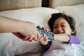 Asian Child On Bed Wants to Take Over TV Remote Control from His Parent Hands. Addiction or Parental Control Concept Royalty Free Stock Photo