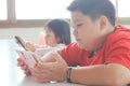 Asian child Boy and girls are addictive playing tablet and mobile phones