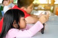 Asian child Boy and girls are addictive playing tablet and mobile phones Royalty Free Stock Photo